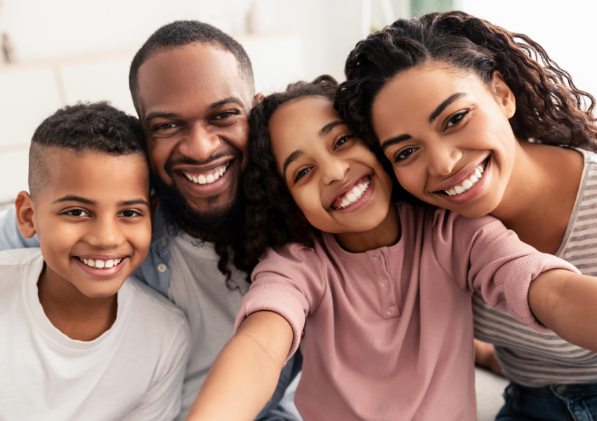 Joyful family selfie with smiling parents and children.