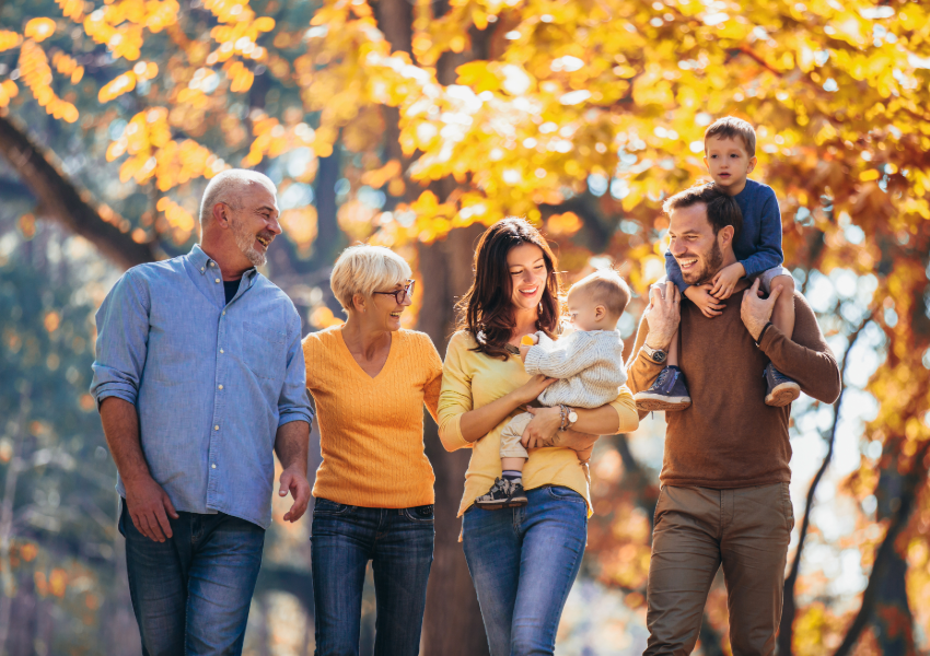 Two generations of a family enjoying a walk in an autumn park.