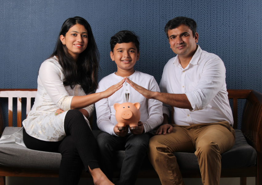 Family holding a piggy bank, symbolizing financial security.