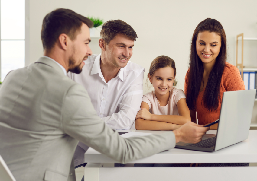 Family consulting with a professional at a desk.