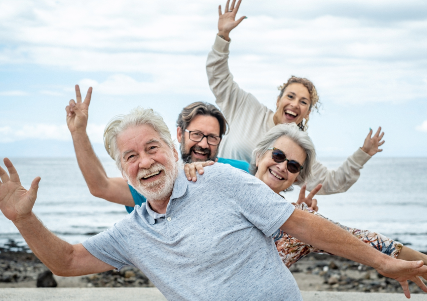 Happy senior group celebrating by the sea.