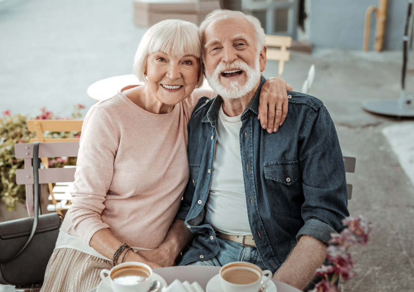 Joyful elderly couple sharing a moment at a café.