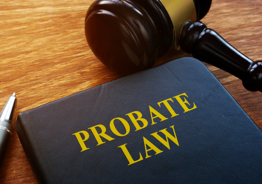 A gavel and a book titled "PROBATE LAW" on a wooden table.