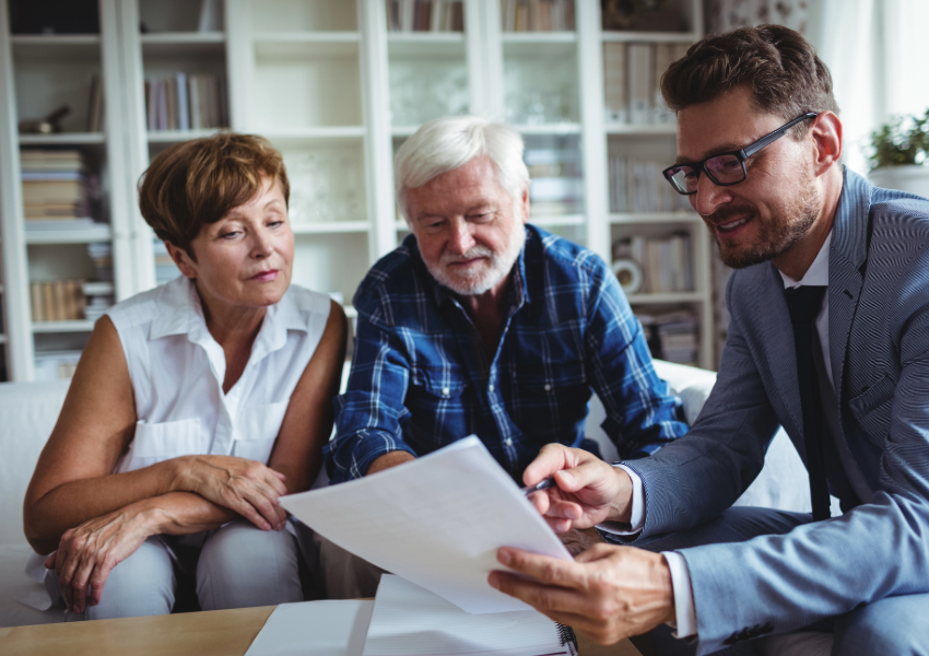 Senior couple reviewing documents with estate planner.